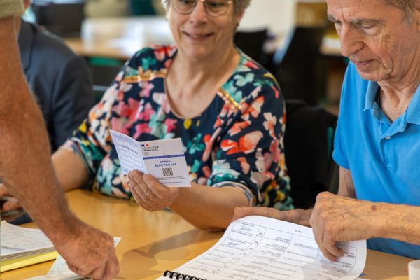 Les assesseurs d'un bureau de vote de Buxerolles contrôlent une carte d'électeur, le 9 juin 2024, jour de vote pour les élections européennes.