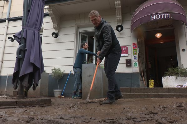 Les habitants et les commerçants d'Annonay nettoient les rues à Annonay, suite aux inondations.