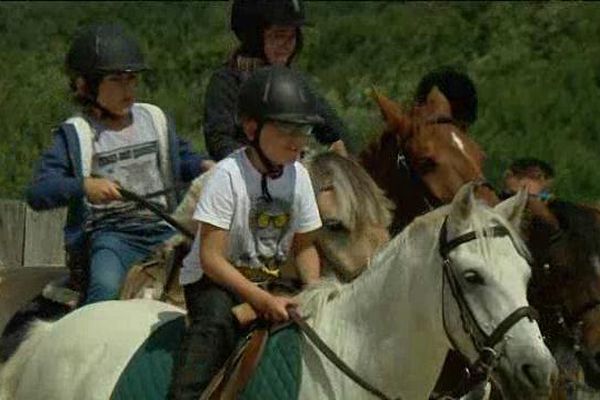 Ethan, 9 ans, au milieu de ses deux copains, est ravi de cavaler sur le poney Malabar !
