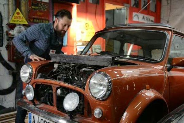 Emerson François en plein travailsur une vieille Mini