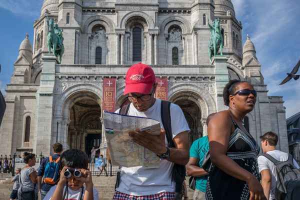 Des touristes photographient le Sacré-coeur, à Paris.