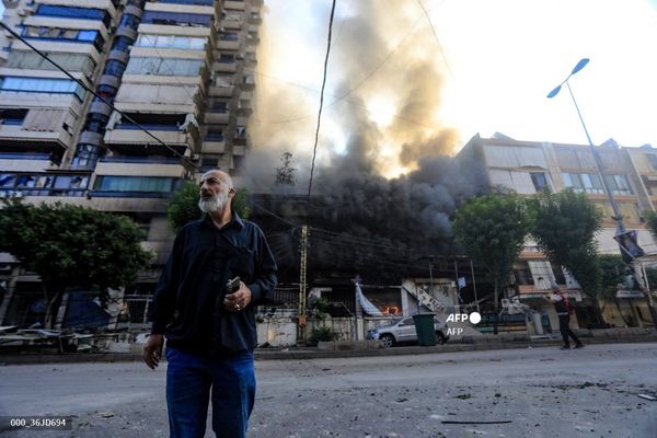 Un homme près d'un immeuble touché par un tir israélien dans la banlieue sud de Beyrouth le 6 octobre 2024.