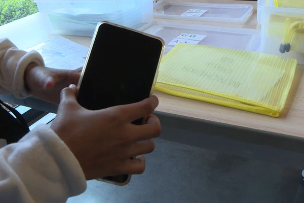 À l'entrée du collège, les élèves de 6ᵉ rangent leurs téléphones dans une pochette. Il sera rangé dans des casiers par classe et récupéré à la fin de la journée.