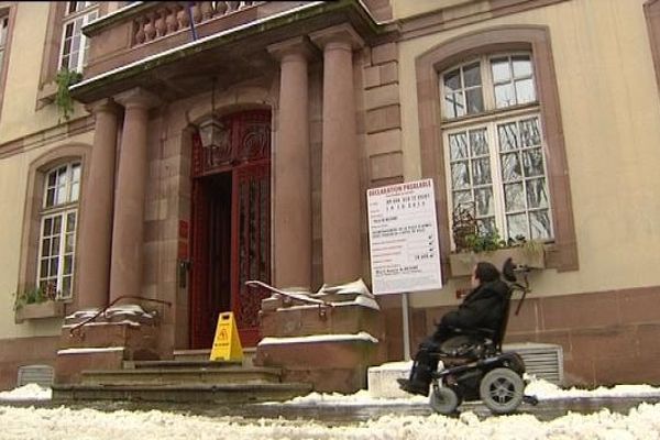 William en fauteuil devant la mairie de Belfort