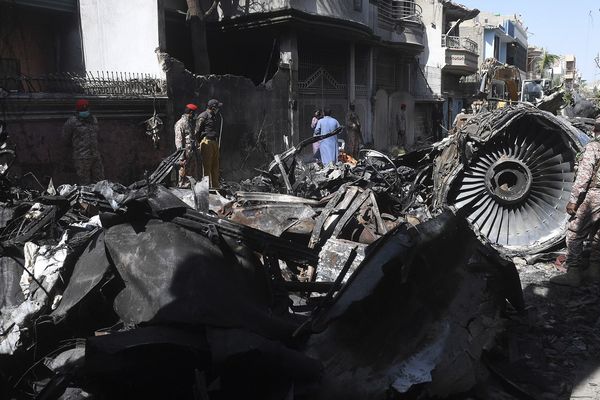 Du personnel de sécurité à côté de l'épave d'un A320, deux jours après que celui-ci se soit écrasé sur les maisons d'un quartier résidentiel de Karachi, au sud du Pakistan, le 22 mai 2020.