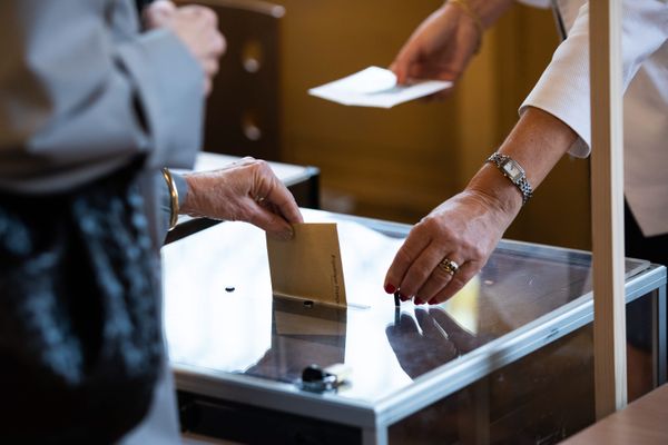 Une électrice glisse son bulletin de vote dans une urne - Photo d'illustration