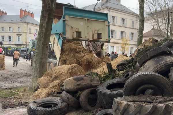 Des agriculteurs déversent de la paille et des pneus devant la maison de l'Europe à Dijon, mercredi 11 décembre 2024.