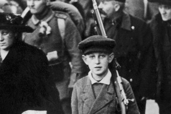 Photographie d'un enfant portant le fusil de son père lors de la mobilisation en Autriche en août 1914.