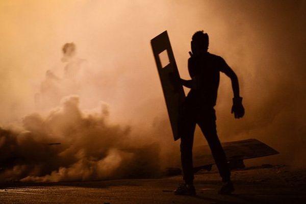 Un homme est encerclé par des tirs de grenade lacrymogène lors d’une manifestation, le 25 juillet 2013 à Diraz. Depuis février 2011, la majorité shiite proteste contre le régime sunnite en place