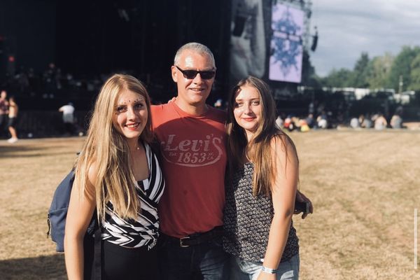 Hervé Cordier (au centre), entouré de ses filles Lola (à gauche) et  Apolline (à droite), devant la grande scène des Eurockéennes de Belfort.