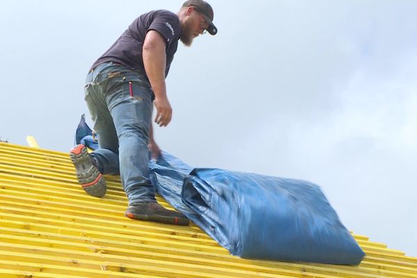 Les couvreurs doivent constamment bâcher leurs chantiers pour les protéger de la pluie. Une opération gourmande en temps.