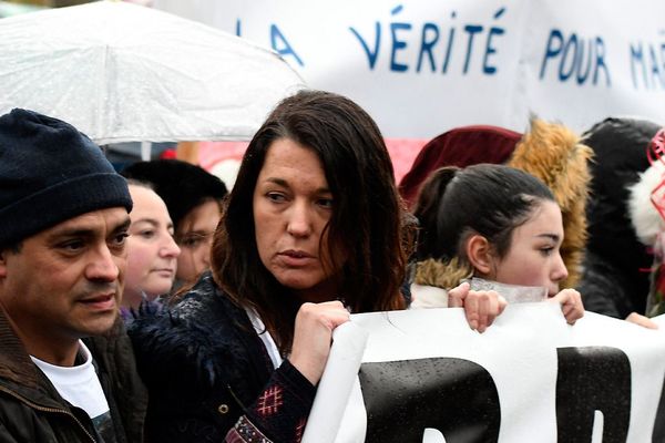 Les parents de Maelys de Araujo, Jennifer et Joachim, tiennent une bannière alors que les gens se rassemblent au Pont-de-Beauvoisin, le 27 décembre 2017.