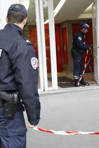 Des policiers établissent un périmètre afin de mener leur enquête après l'accident qui a fait trois blessés graves, une femme et ses deux enfants, à la suite d'une chute de six étages, d'une cabine d'ascenseur dans un immeuble du XIe arrondissement de Paris (2011)