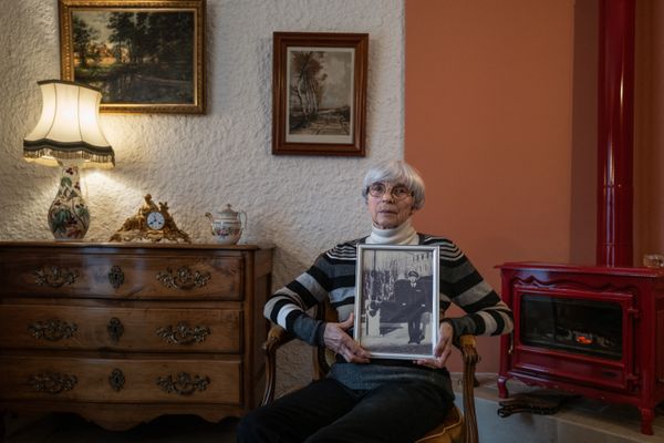 Michèle Larmier, veuve du capitaine de frégate Claude Larmier, pose à Vincelles (Yonne) le 30/11/2023 avec le portrait de son mari défunt qui avait assisté à cinq essais nucléaires en 1968 depuis le porte-avions Clémenceau en Polynésie