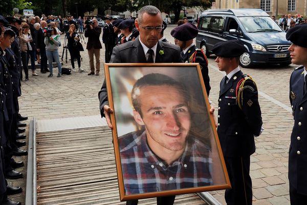 Un homme porte une photo du caporal Arthur Noyer, lors de ses funérailles, en septembre 2018.