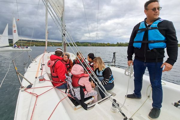 La majorité des participants au projet de voile thérapeutique souffrent de déficiences mentales sévères à lourdes. Sur cette photo, quatre participants, accompagnés de quatre éducateurs dont Christian Maron, (debout à droite). Lundi 16 septembre 2024.