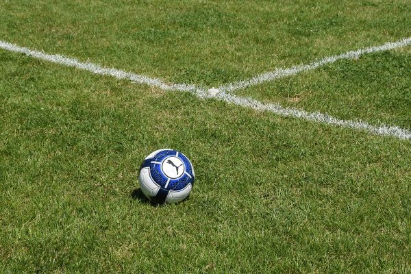 Ballon de football abandonné sur un côé de terrain.