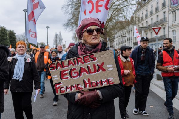 Femme portant une pancarte pour l'égalité salariale entre les hommes et les femmes lors de la deuxième journée de manifestation contre la réforme des retraites, en 2023, à Nantes.