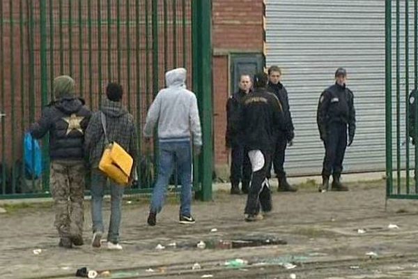 Des migrants sous surveillance policière à Calais.  