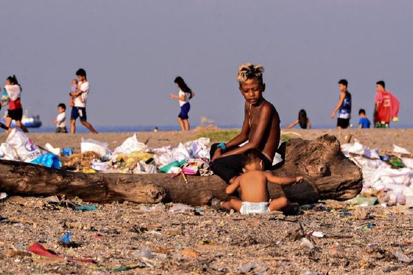 Une plage de Manille où les enfants jouent au milieu des détritus déposés par l'océan.