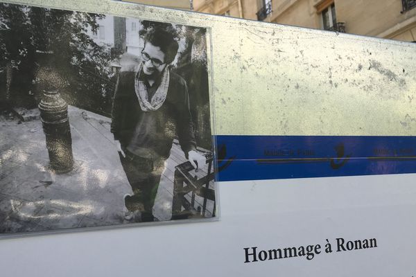 Une photo de Ronan en noir et blanc trône au milieu des fleurs.