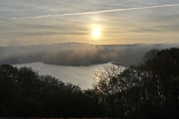 Lever de soleil sur la chaîne du Sancy avec le plan d'eau de Bort-les-Orgues au premier plan