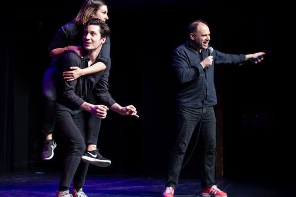 Le fondateur de l'école sur scène, avec deux membres de la troupe des Improvisateurs