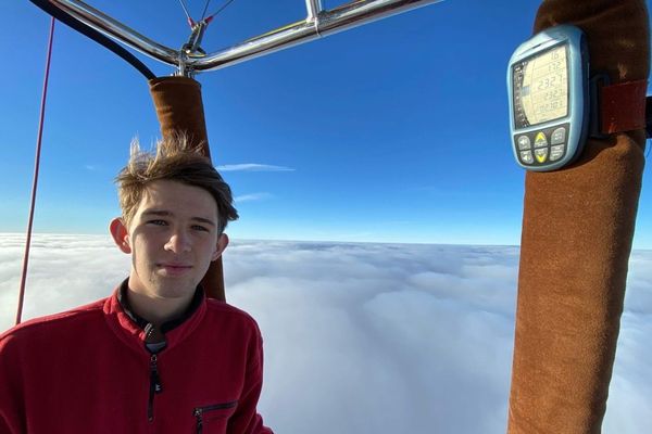 A bord de sa montgolfière, seul au dessus des nuages