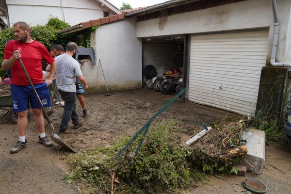 Les habitants de l'Albenc, en Isère, déblayent le limon dans les rues du village le 25 juin 2024, au lendemain des inondations.