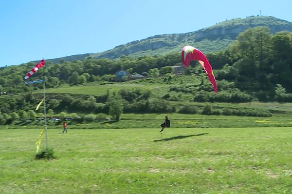 Jeff Thurel guide un parapentiste au moment de son atterrissage.