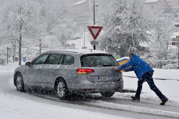 Dans la région de Saint-Etienne, un automobiliste pousse sa voiture sous la neige