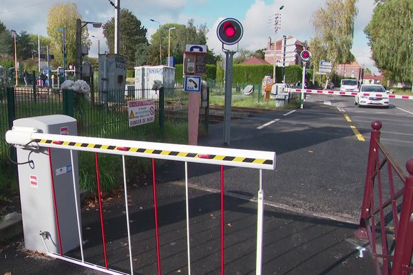 Le passage à niveau de Wavrin. Au premier plan, une barrière piétonne, au second les barrières pour automobiles.