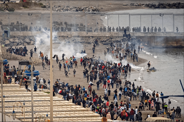 Les forces de sécurité espagnoles tentent de repousser l'afflux de migrants qui essayent de franchir la frontière de l’enclave.