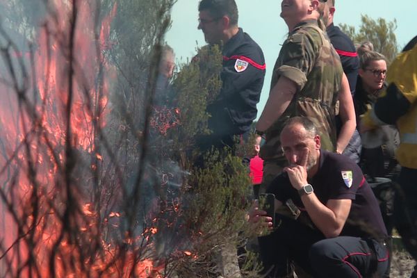 Pompiers et militaires suivent l'exercice attentivement.