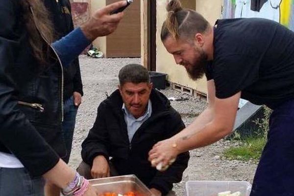 Florent Ladeyn distribue les repas qu'il a préparé avec les migrants.