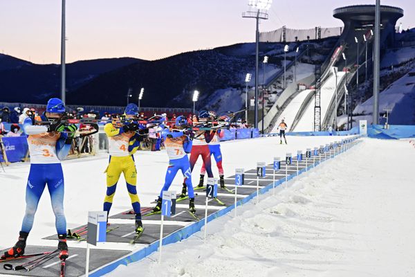 Le biathlète grenoblois Emilien Jacquelin (au premier plan à gauche) sur le pas de tir lors de l'épreuve du relais mixte aux Jeux de Pékin.