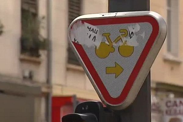 Le nouveau panneau est composé d’un pictogramme de couleur jaune représentant un vélo qui apparaît sur un fond blanc bordé d’une bande rouge.  Une flèche de couleur jaune indique aux cyclistes la direction à suivre, à droite ou tout droit s’il n’y a pas de voie à droite.