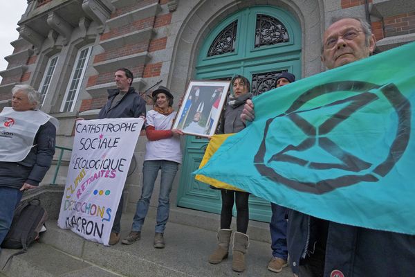 La militante écologiste Lucie Auvray (au centre, avec le tee-shirt blanc) porte le portrait d'Emmanuel Macron qu'elle vient de décrocher à la mairie de La Haye-Pesnel (Manche), en mars 2020, lors de l'action militante qui lui a valu une garde à vue et une condamnation.