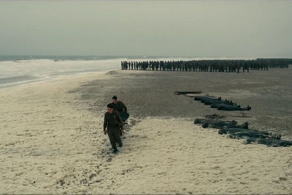 Les aceteurs Fionn Whitehead et Aneurin Barnard évacuant un blessé de la plage de Dunkerque