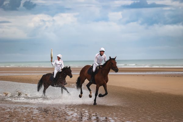 L'humoriste Nicolas Canteloup et la championne d'équitation Pénélope Leprévost portent la flamme olympique sur Omaha Beach, dans le Calvados.