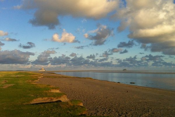 Entre le ciel, la terre et l'eau : le Mont Saint Michel émerge en toute majesté, lors des grandes marées.