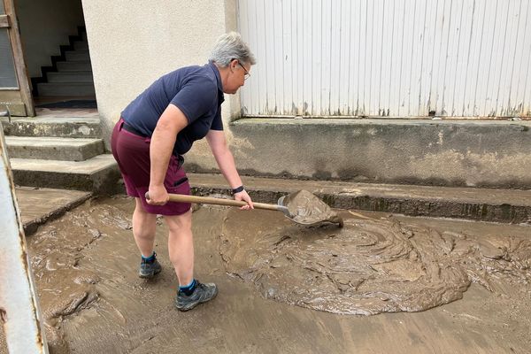 Cette habitante de Thiers nettoie la boue accumulée devantr chez elle. Deux jours après le violent orage qui s'est abattu sur la commune, samedi 20 juillet.