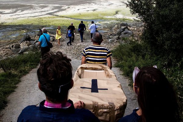 Des militants portent un cercueil sur la plage de Grandville à Hillion, pour un enterrement symbolique