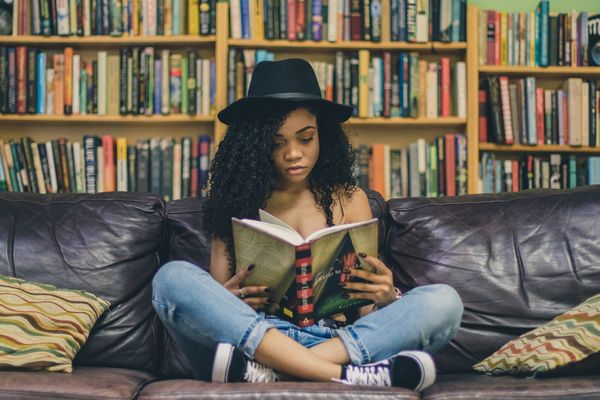 Femme lisant un livre dans une bibliothèque.