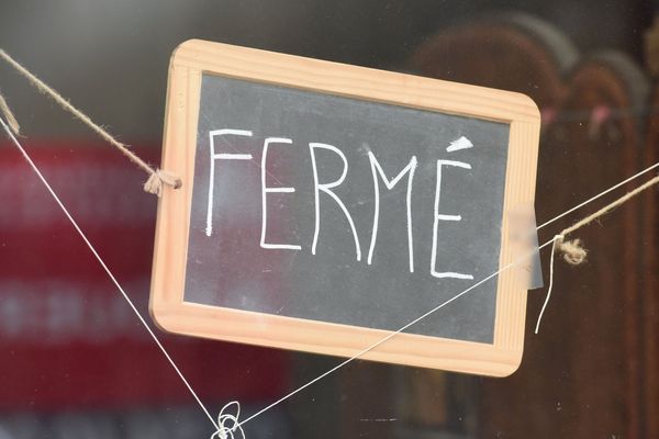 Un panneau "fermé" sur la devanture d'une entreprise. 