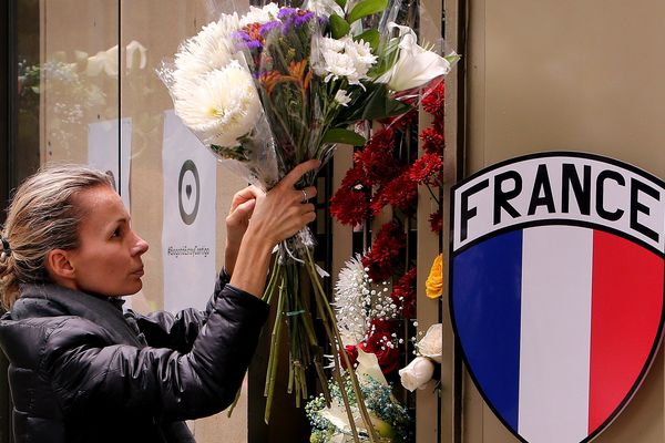 Ambassade de France à Bogota : une femme dépose une gerbe de fleurs en hommage à Julie Huynh, victime d'un attentat.