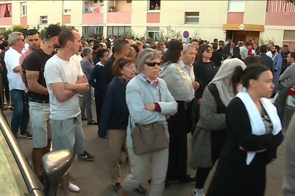 Gard - La foule silencieuse a fait une halte devant l'immeuble des parents de la victime à Vauvert lors de la marche en hommage à Redouane Abbaoui, l'entraîneur de football poignardé à 7 reprises - mai 2019.