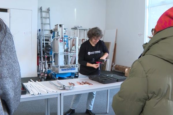 Olga Alexandre présente les différents outils avec lesquels elle travaille chaque jour aux femmes visitant l'école Gustave