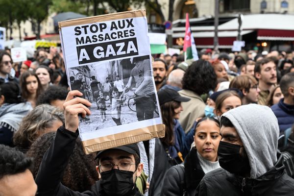 Un manifestant avec une pancarte "Stop aux massacres à Gaza" lors du rassemblement en soutien aux Palestiniens ce samedi à Paris.