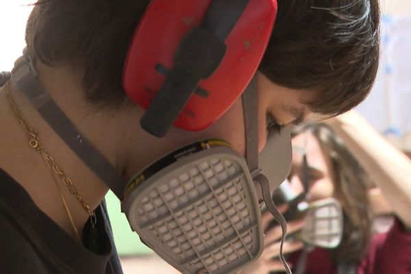 Une élève apprend à travailler le bois dans un atelier